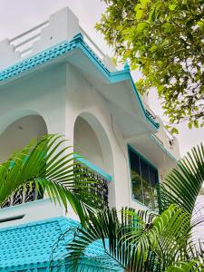 a white house with a blue roof at Lima Beach House Varkala in Varkala