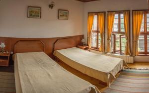 two beds in a room with windows at Pachilov House in Zlatograd