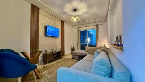 Una sala de estar con un sofá azul y una mesa. en Super appart vue sur mer, en Rabat