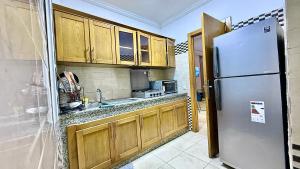 Una cocina con gabinetes de madera y un refrigerador de acero inoxidable. en Super appart vue sur mer, en Rabat