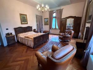 a bedroom with a bed and a couch and chairs at Io&Te La Suite di Villa Monteriolo in Canelli