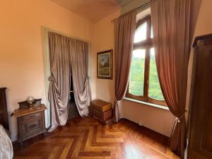 a bedroom with two large windows and a wooden floor at Io&Te La Suite di Villa Monteriolo in Canelli +37 photos