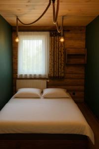 Wola MichowaにあるChatka Wagabundyの窓のある大きなベッドのある寝室