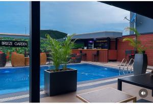 una piscina con plantas al lado de un edificio en Starview Terrace Hotel, en Badore
