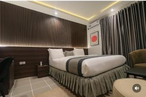 una habitación de hotel con una cama grande y una silla en Starview Terrace Hotel, en Badore