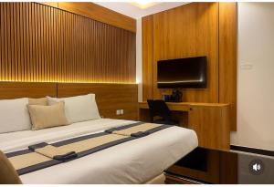 una habitación de hotel con una cama y un televisor en Starview Terrace Hotel, en Badore