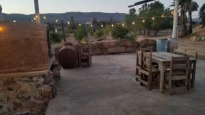 Un patio con mesa y sillas y un muro de piedra. en DaNik Valle, en Francisco Zarco