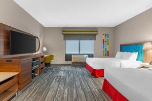 a hotel room with two beds and a flat screen tv at Hampton Inn Junction City in Junction City +12 photos