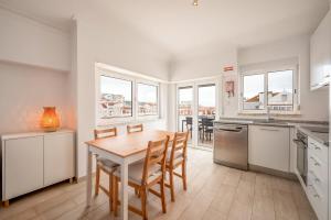 a kitchen with a table and chairs in a room at GuestReady - Sunny Retreat in Costa da Caparica in Costa da Caparica