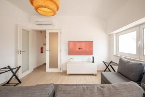 a living room with a couch and a flat screen tv at GuestReady - Sunny Retreat in Costa da Caparica in Costa da Caparica