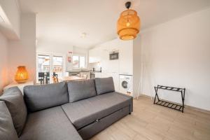 a living room with a couch and a kitchen at GuestReady - Sunny Retreat in Costa da Caparica in Costa da Caparica