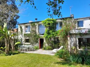 a house with a garden and a red door at Grande maison avec extension d'architecte à 700m de la plage in Brest