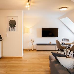 een woonkamer met een bank en een tafel bij Allgäu Suites - Innenstadt, Schlafzimmer, Küche, Parkplatz möglich, Dachterrasse in Kempten