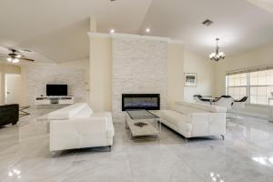 ein Wohnzimmer mit weißen Möbeln und einem Kamin in der Unterkunft Outdoor Kitchen and Patio Loxahatchee Oasis! in Royal Palm Beach