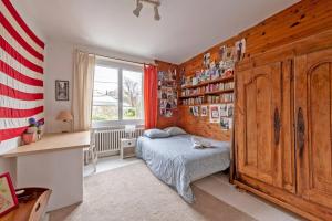 a bedroom with a bed and a book shelf at Grande maison avec extension d'architecte à 700m de la plage in Brest