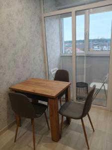 einen Holztisch und Stühle in einem Zimmer mit Fenster in der Unterkunft New Comfort Apartment in Hostomelʼ + 2 Fotos
