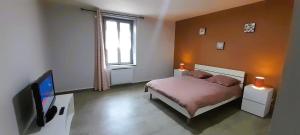 a bedroom with a bed and a flat screen tv at Le St Roch - appart 6-8 pers - wifi - centre ville in Issoudun