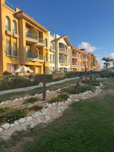 uma fileira de prédios de apartamentos ao lado de um campo de grama em Elabd Family Porto Chalet em Marsa Matruh