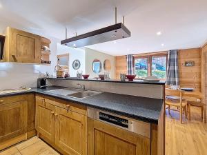 eine Küche mit Holzschränken, Spüle und Herd in der Unterkunft Appartement spacieux et confortable A proximité des pistes Balcon WIFI - FR-1-344-771 in Saint-Martin-de-Belleville