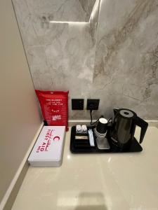 a tray with a coffee maker and a book on a counter at الواجهة in Buraydah