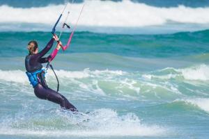 a person riding a wave on a surfboard in the ocean at Grande maison avec extension d'architecte à 700m de la plage in Brest