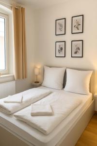 a white bed with white sheets and pillows at Allgäu Suites - Innenstadt, Schlafzimmer, Küche, Parkplatz möglich, Dachterrasse in Kempten +37 photos