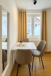 een eetkamer met een witte tafel en stoelen bij Allgäu Suites - Innenstadt, Schlafzimmer, Küche, Parkplatz möglich, Dachterrasse in Kempten