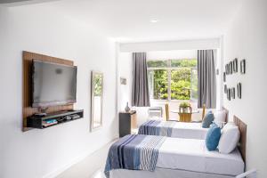 ein Hotelzimmer mit zwei Betten und einem Fernseher in der Unterkunft Studio Solar de Copacabana Vista Mar in Rio de Janeiro