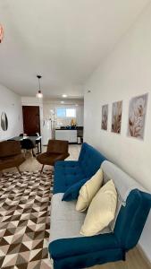 a blue couch in a living room with a kitchen at Beach Place ACONCHEGO e refúgio perto do mar in Cumbuco