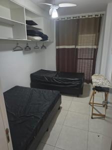 Una habitación con dos camas y una silla dentro. en Apartamento em Mongaguá, Frente ao Mar, en Mongaguá 20 fotos más