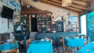 a restaurant with two blue tables in a room at Villa Rena in Batsi