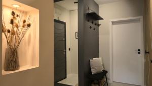 einen Flur mit einer Blumenvase und einer Tür in der Unterkunft LUXURY Designer Apt I Meters to Gondola Lift I Sleeps 6 I Pool & Parking I in Bansko