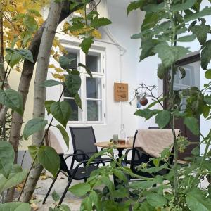 a patio with a table and chairs and a tree at Patak & Stone apartman in Szentendre
