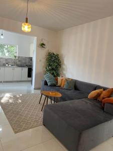 a living room with a blue couch and a table at שירת רבקה in Tiberias