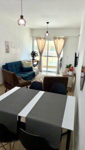a living room with a table and a blue couch at Beach Place ACONCHEGO e refúgio perto do mar in Cumbuco