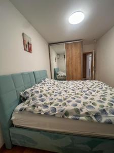 a bedroom with a bed with a blue bedspread at Bulevar in Sarajevo