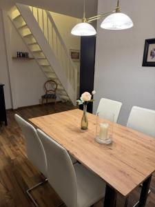 a wooden table with a vase of flowers and a candle at Schöne Wohnung mit Aussicht in Oettingen in Bayern