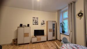 een woonkamer met een televisie en een witte kast bij Sarantis Apartment in Old Town Gdansk in Gdańsk
