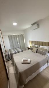 a bedroom with a large bed with two towels on it at Beach Place ACONCHEGO e refúgio perto do mar in Cumbuco +18 photos