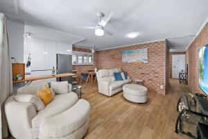 マルーチードールにあるRiverfront Bliss Luxe Pet-Friendly Escapeの白い家具とレンガの壁が備わるリビングルーム