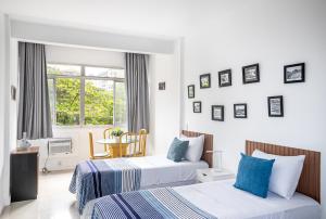 ein Hotelzimmer mit zwei Betten und einem Tisch in der Unterkunft Studio Solar de Copacabana Vista Mar in Rio de Janeiro