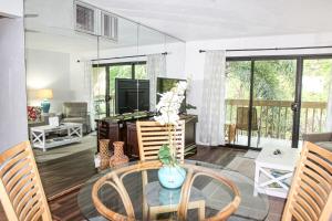 a living room with a glass table and chairs at 2b2b AC Magic Tides Kona near Magic Sands Beach in Kailua-Kona