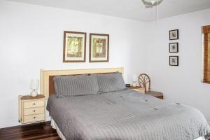 a white bedroom with a bed and a nightstand and a window at 2b2b AC Magic Tides Kona near Magic Sands Beach in Kailua-Kona +61 photos