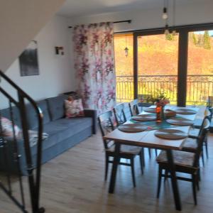 a living room with a table and chairs and a couch at Siedem Światów Domek in Jurgów