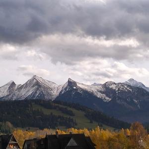 a mountain range with snow capped mountains in the distance at Siedem Światów Domek in Jurgów