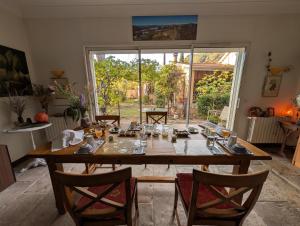 a dining room with a large wooden table and chairs at Chambres d'Hôtes - Le Pin des Arches in Digne-les-Bains