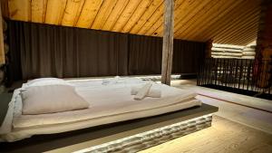 een groot bed in een kamer met een houten plafond bij Kelokurki - The Luxury Lodge Where Serenity Meets the Northern Lights in Levi