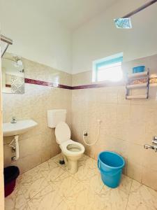 a bathroom with a toilet and a sink at Lima Beach House Varkala in Varkala