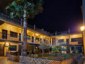 a palm tree in front of a building at night at HOTEL RESTAURANT LA KaSBAH in Tinerhir