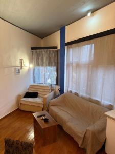 a bedroom with a bed and a couch and a window at Blue Note in Mytilini